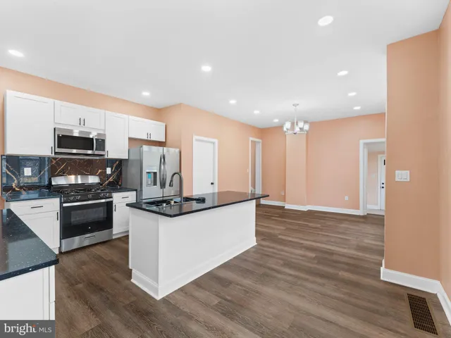 a kitchen with stainless steel appliances granite countertop a stove a sink and a refrigerator