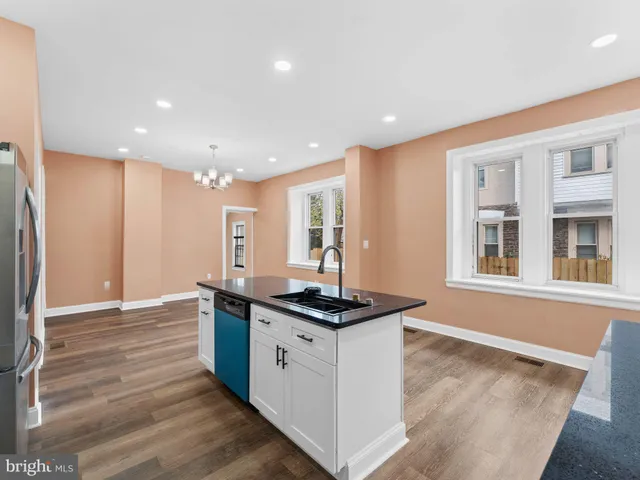 a kitchen with stainless steel appliances kitchen island granite countertop a refrigerator and a sink