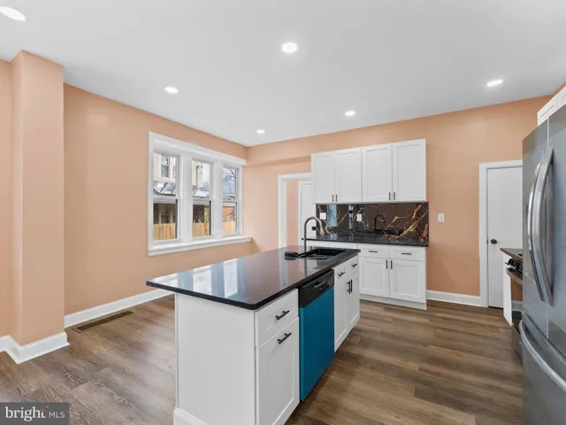 a kitchen with stainless steel appliances granite countertop a sink a stove and a microwave