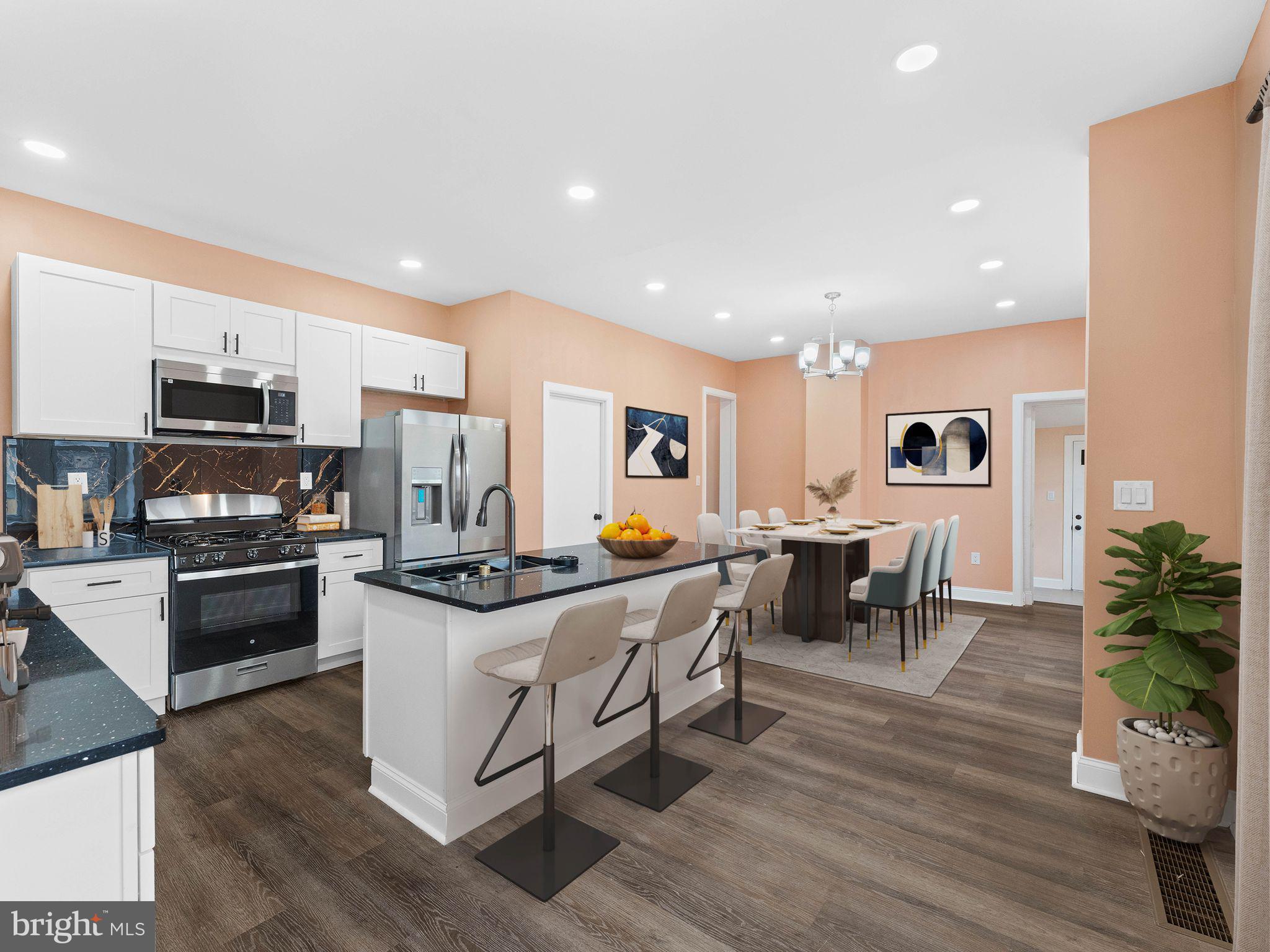 413 High Street Philadelphia, PA 19144 - Photo 2 of 37 a kitchen with stainless steel appliances granite countertop a stove top oven a sink a dining table and chairs with wooden floor