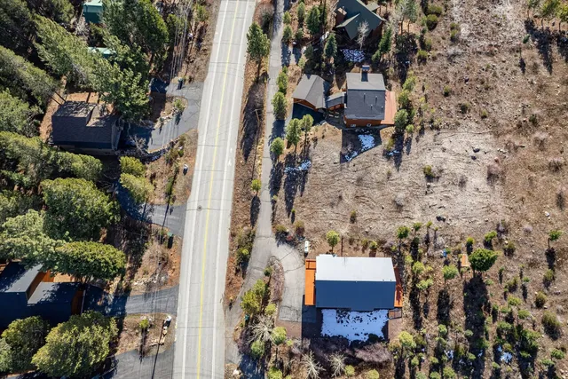 an aerial view of a house with a yard and large trees