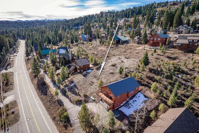 an aerial view of a house with a yard and mountain