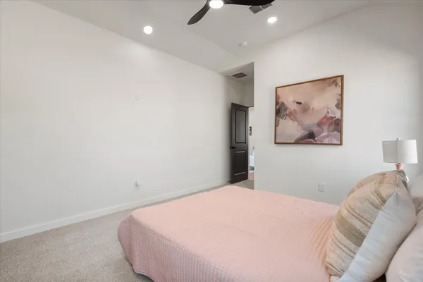 a bedroom with a bed and a painting on the wall