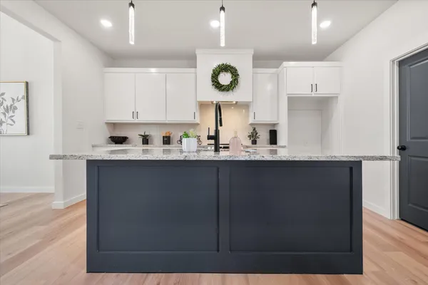 a kitchen with a sink a refrigerator and cabinets