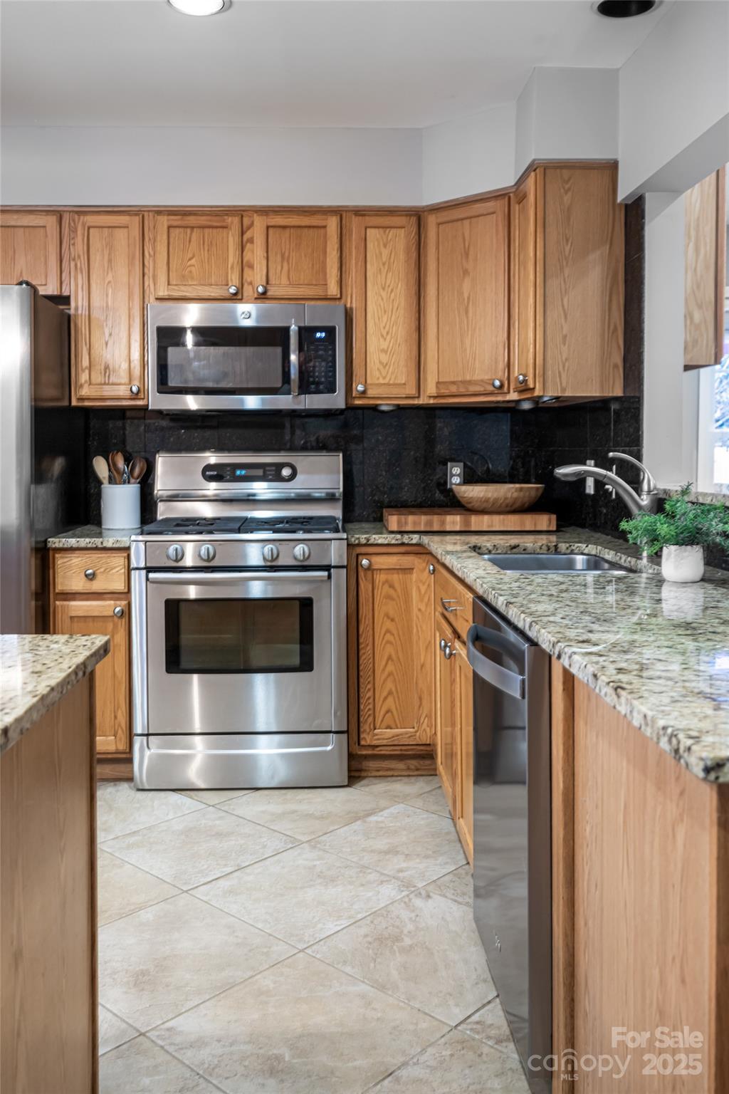 315 Glenn Bridge Road Arden, NC 28704 - Photo 17 of 45 a kitchen with granite countertop a stove top oven microwave and cabinets