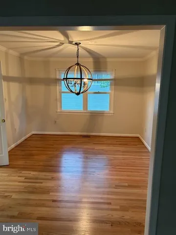 a view of a room with wooden floor and cabinets