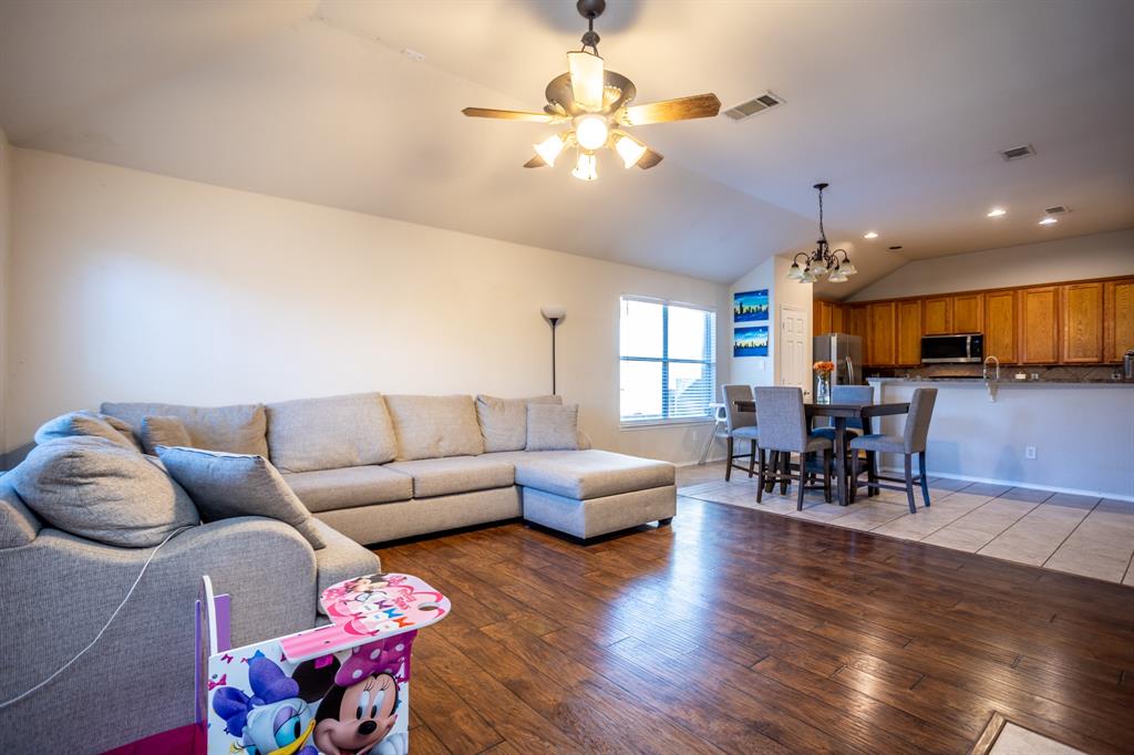 536 Cross Ridge Circle Fort Worth, TX 76120 - Photo 11 of 23 Living room featuring ceiling fan with notable chandelier, lofted ceiling, and hardwood / wood-style flooring