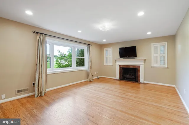 a view of empty room with wooden floor and fireplace