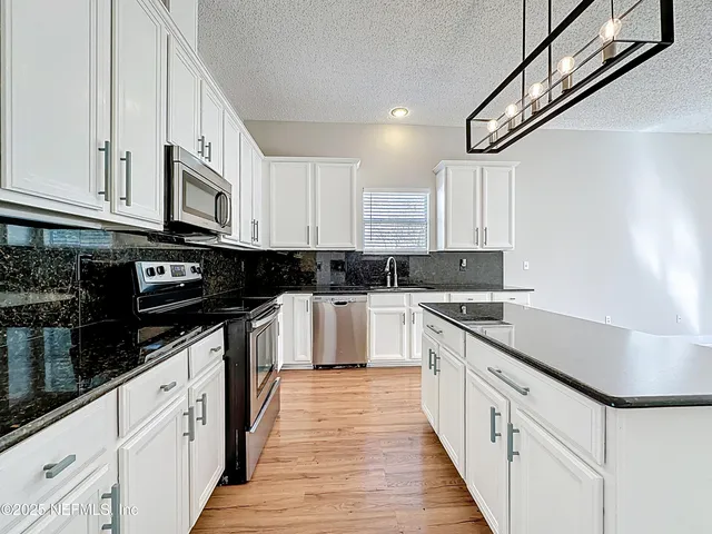 a kitchen with stainless steel appliances granite countertop a sink and cabinets