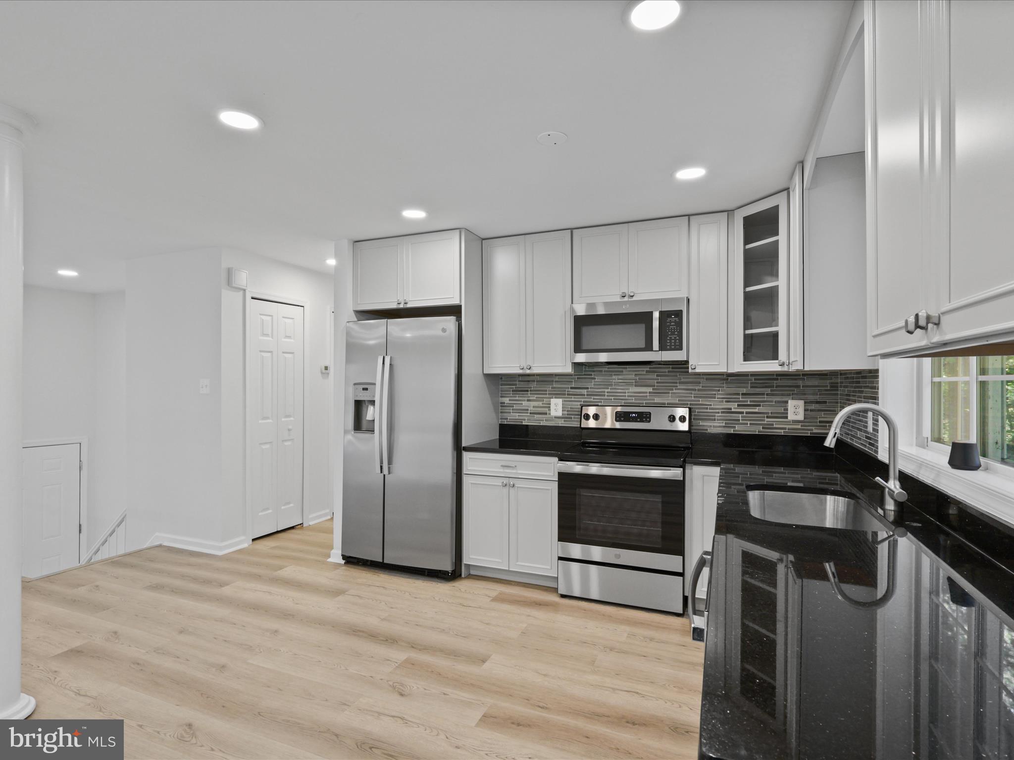2369 Old Trail Drive Reston, VA 20191 - Photo 15 of 50 a kitchen with stainless steel appliances granite countertop a stove a refrigerator and a microwave