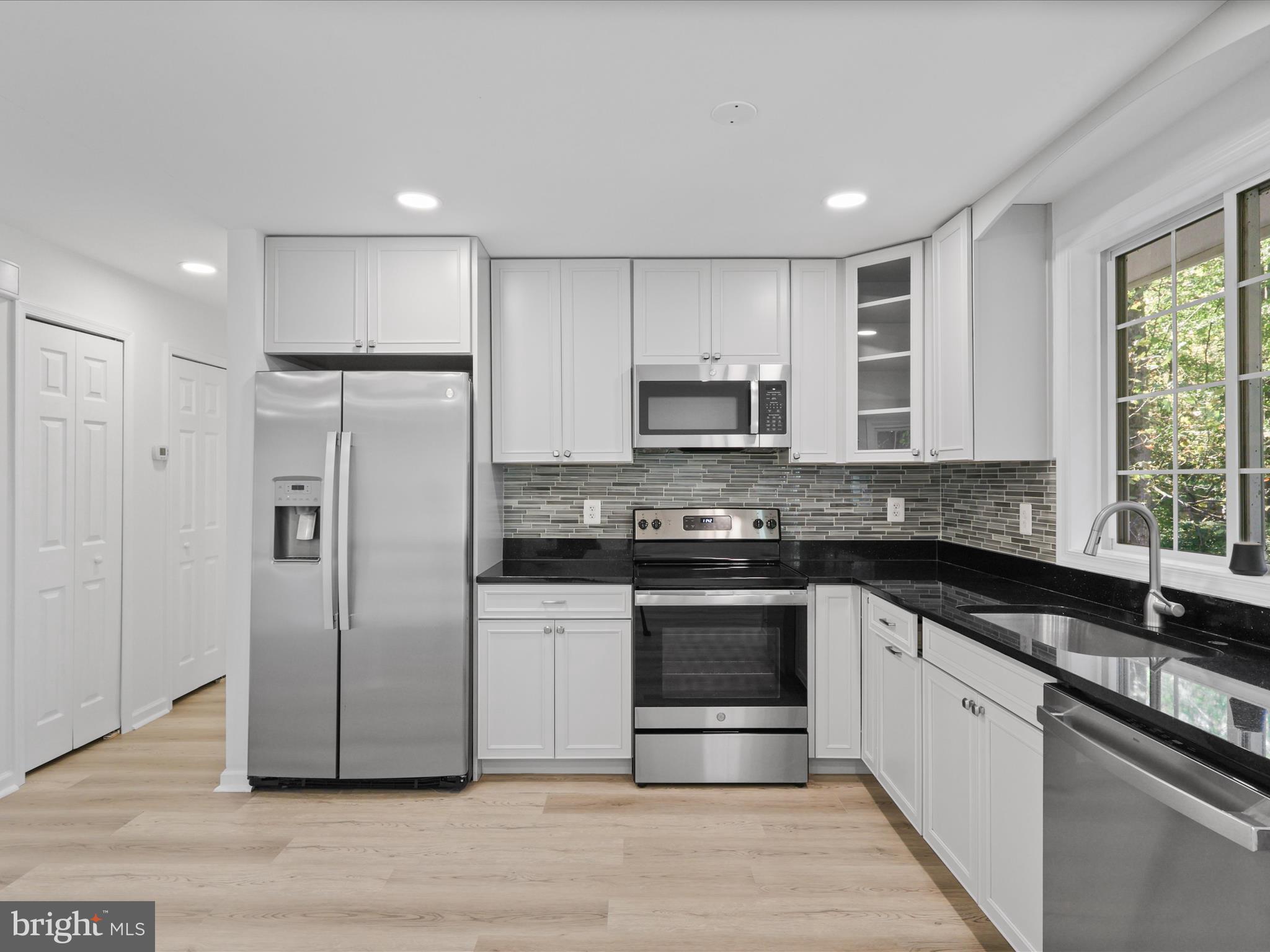 2369 Old Trail Drive Reston, VA 20191 - Photo 16 of 50 a kitchen with stainless steel appliances granite countertop a refrigerator a stove a sink and a microwave