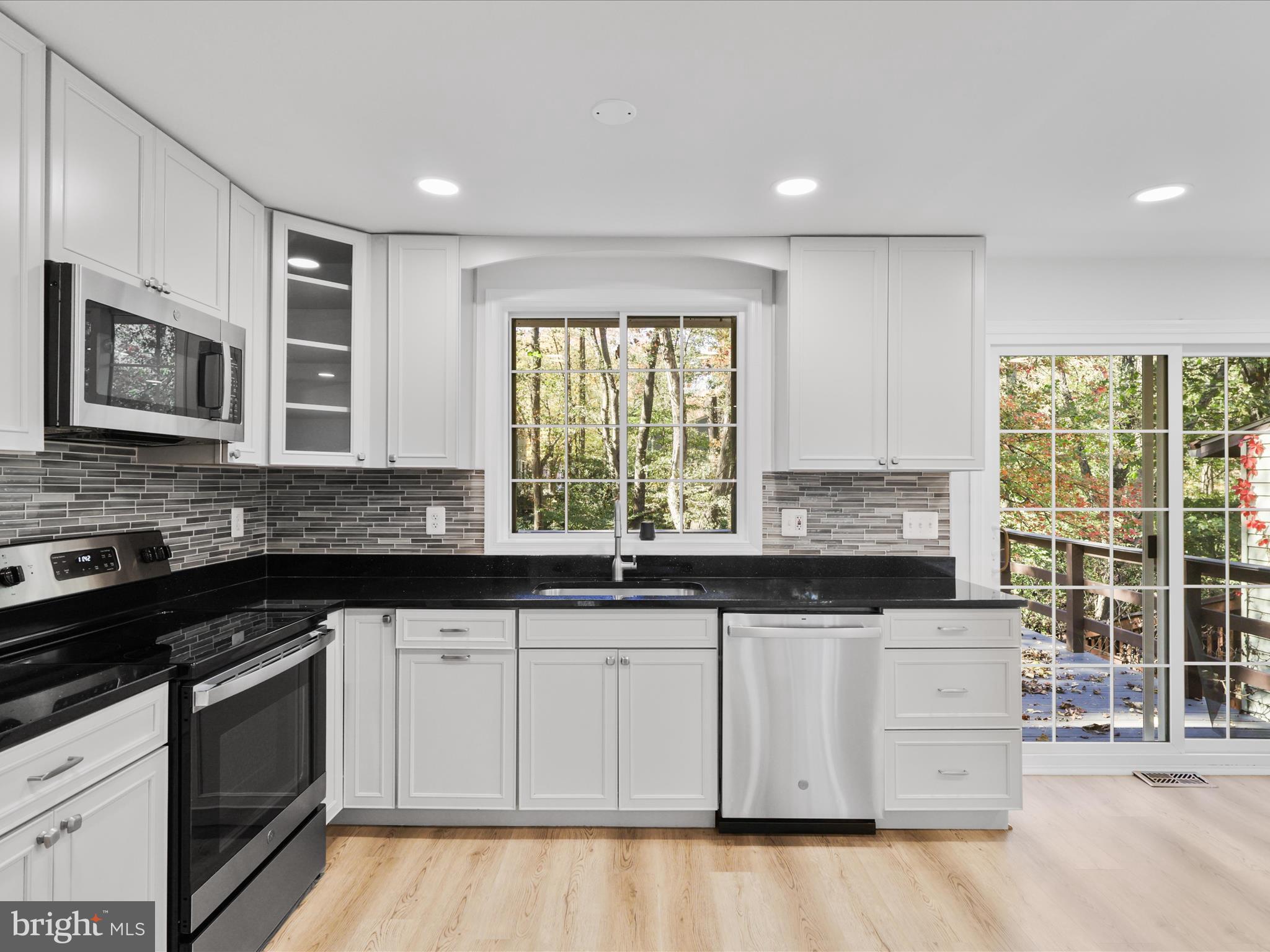 2369 Old Trail Drive Reston, VA 20191 - Photo 17 of 50 a kitchen with granite countertop white cabinets and black stainless steel appliances