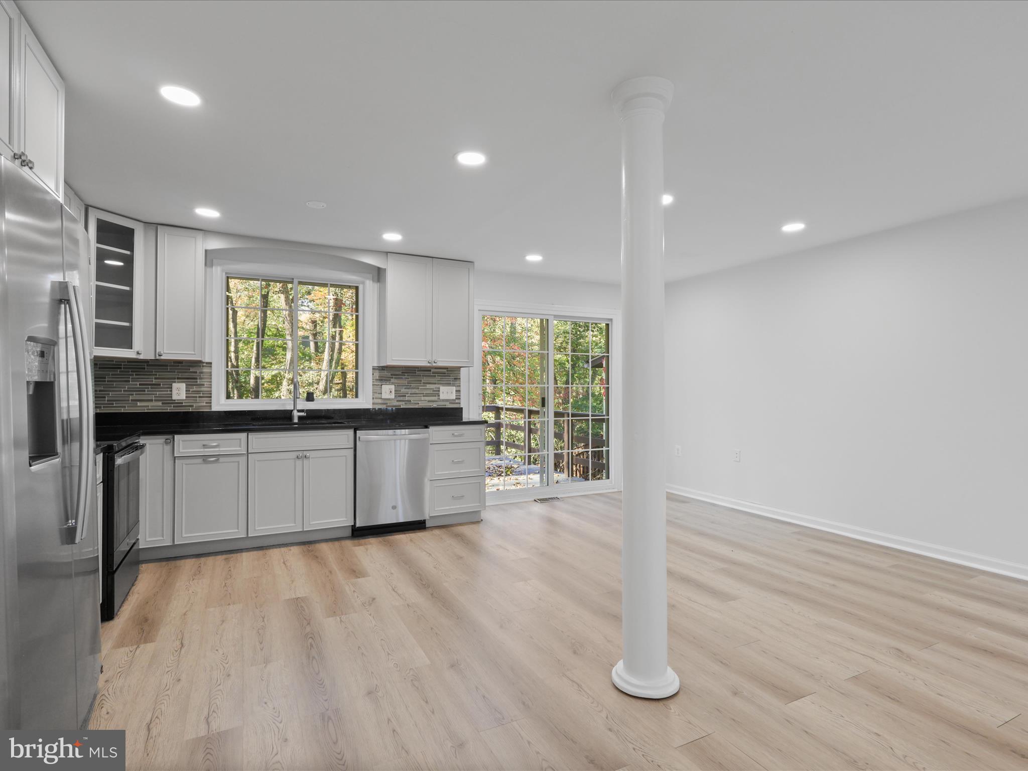 2369 Old Trail Drive Reston, VA 20191 - Photo 7 of 50 a large kitchen with granite countertop a stove a sink a refrigerator and white cabinets with wooden floor