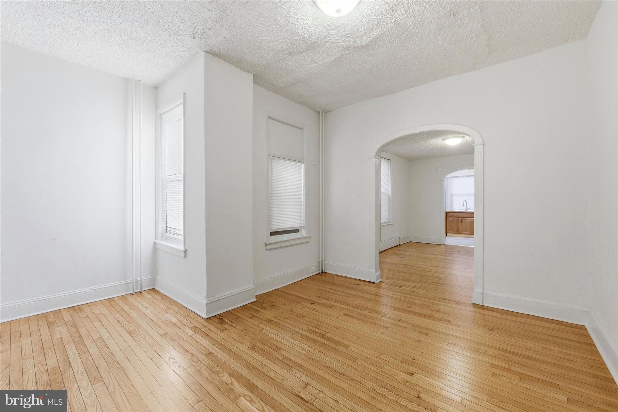 1925 South 21st Street Philadelphia, PA 19145 - Photo 4 of 15 a view of an empty room with wooden floor and a window
