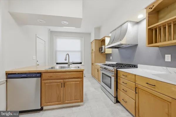 a kitchen with stainless steel appliances granite countertop a sink stove and cabinets