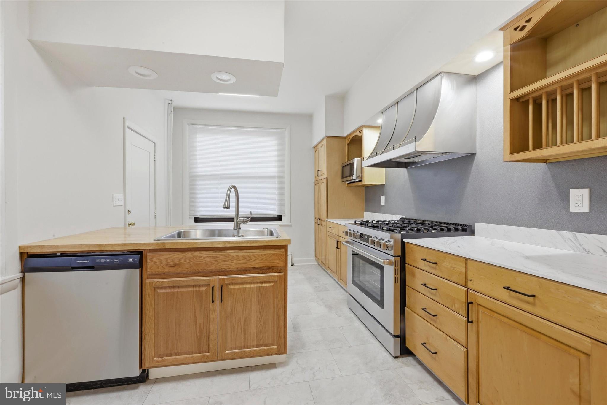 1925 South 21st Street Philadelphia, PA 19145 - Photo 6 of 15 a kitchen with stainless steel appliances granite countertop a sink stove and cabinets