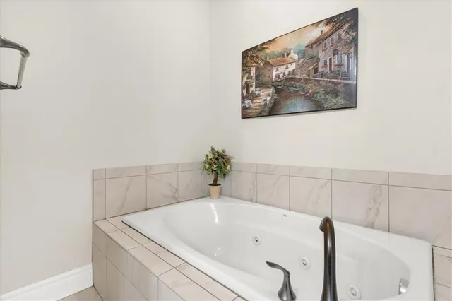 a white bath tub sitting next to a white wall