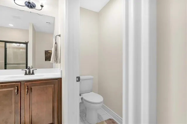 a bathroom with a granite countertop sink toilet and a mirror