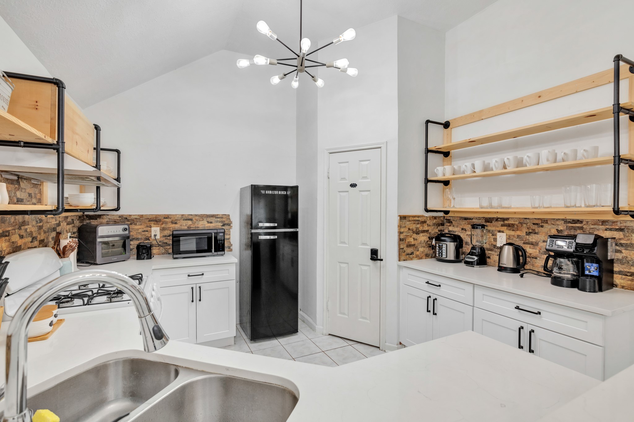 8222 Viny Ridge Drive Houston, TX 77083 - Photo 11 of 34 a kitchen with stainless steel appliances a stove a sink and a refrigerator with white cabinets