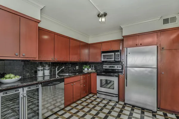 a kitchen with stainless steel appliances granite countertop a refrigerator and a stove top oven