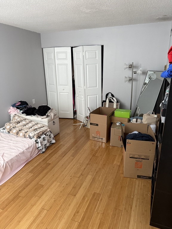 100 Captains Row, Unit 203 Chelsea, MA 02150 - Photo 11 of 16 a bedroom with a bed and wooden floor