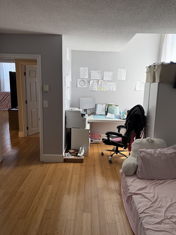 100 Captains Row, Unit 203 Chelsea, MA 02150 - Photo 12 of 16 a living room with furniture and a wooden floor