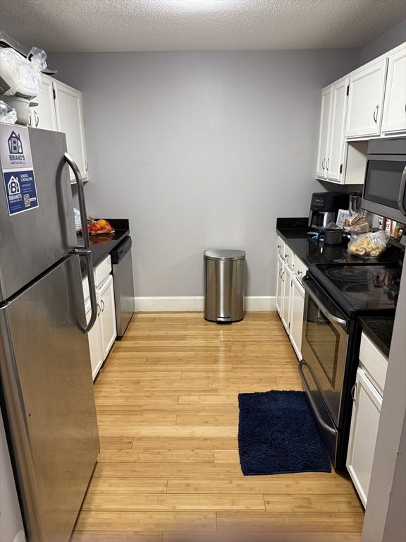 100 Captains Row, Unit 203 Chelsea, MA 02150 - Photo 5 of 16 a kitchen with a sink and wooden floor