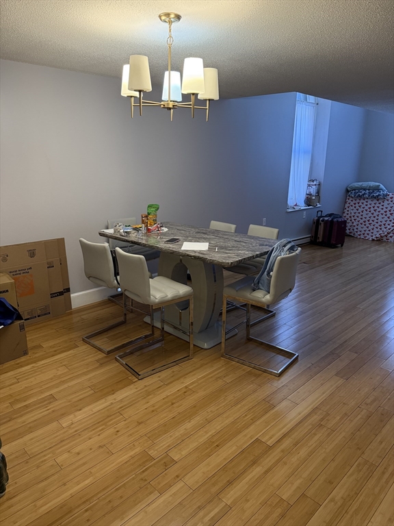 100 Captains Row, Unit 203 Chelsea, MA 02150 - Photo 6 of 16 a view of a dining room with furniture and wooden floor