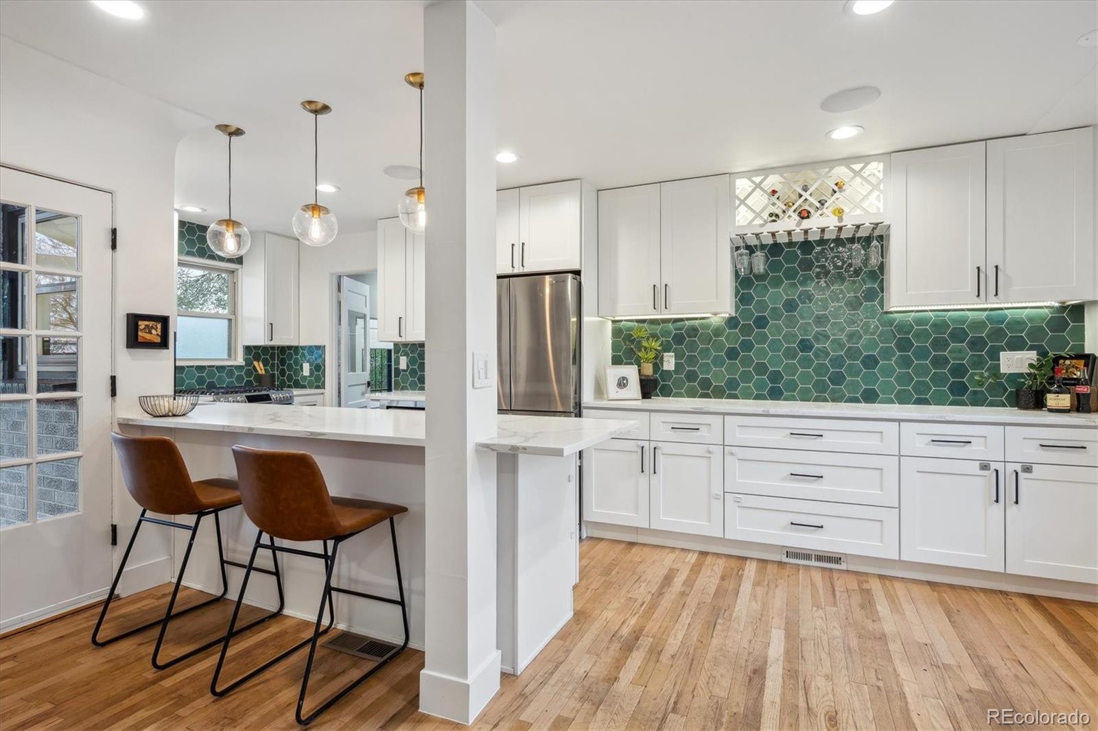 3200 Ames Street Wheat Ridge, CO 80212 - Photo 13 of 46 a large kitchen with kitchen island white cabinets and stainless steel appliances