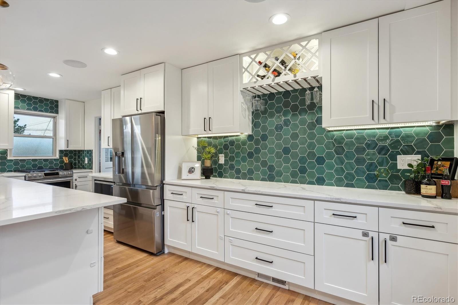 3200 Ames Street Wheat Ridge, CO 80212 - Photo 15 of 46 a kitchen with white cabinets and stainless steel appliances