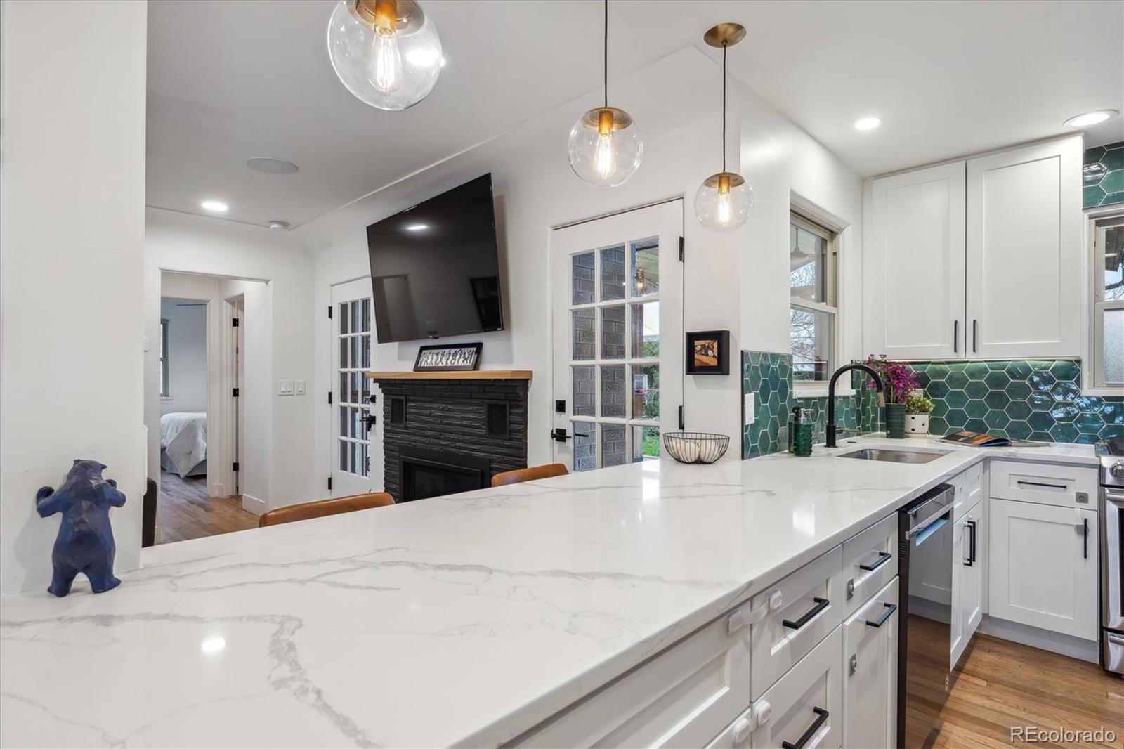 3200 Ames Street Wheat Ridge, CO 80212 - Photo 19 of 46 a kitchen with kitchen island granite countertop a sink a counter top space stainless steel appliances and cabinets