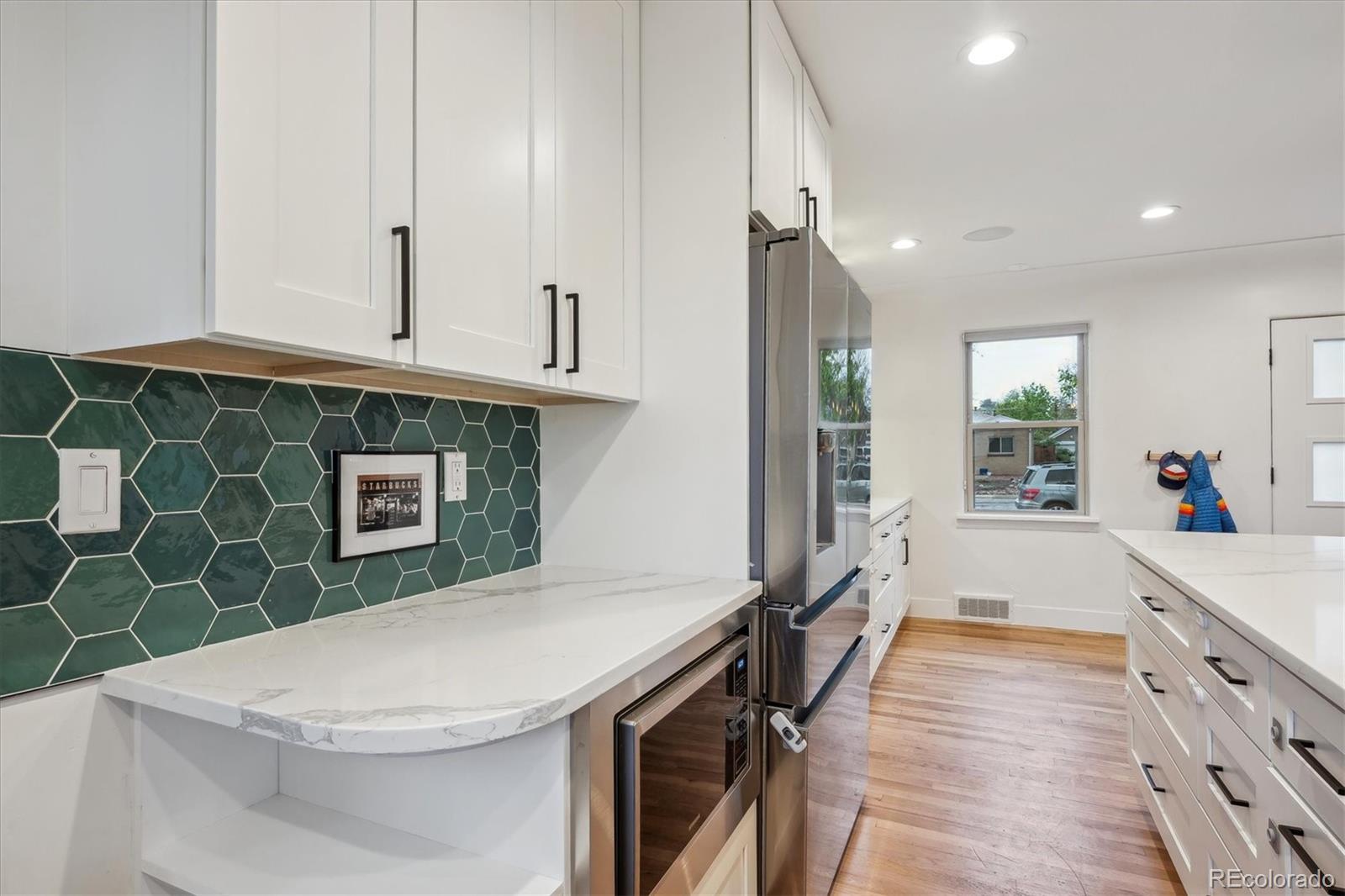 3200 Ames Street Wheat Ridge, CO 80212 - Photo 24 of 46 a kitchen with stainless steel appliances a sink a stove a refrigerator cabinets and living room view