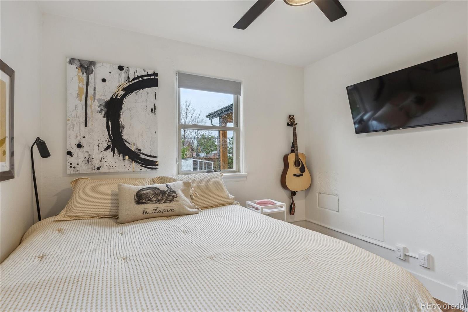 3200 Ames Street Wheat Ridge, CO 80212 - Photo 27 of 46 a bedroom with a bed a window and flat screen tv