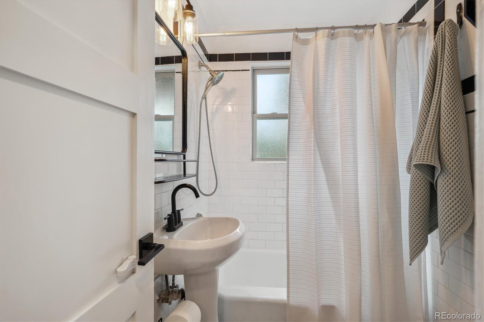 3200 Ames Street Wheat Ridge, CO 80212 - Photo 28 of 46 a bathroom with a sink a mirror and shower