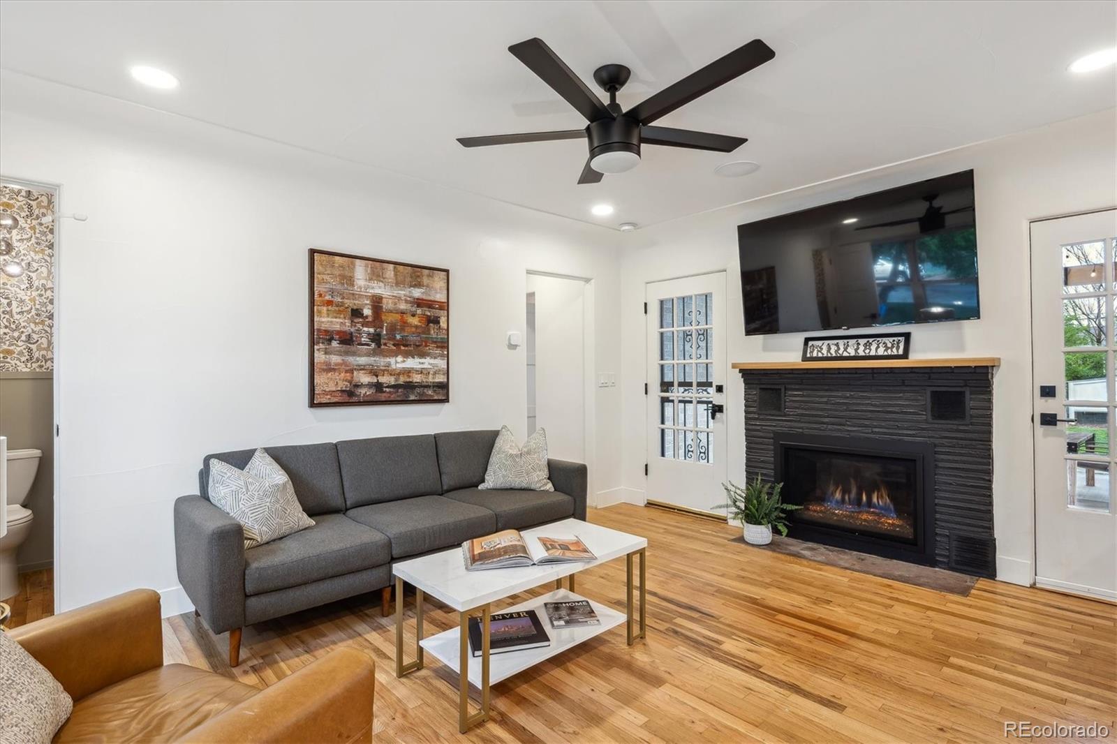 3200 Ames Street Wheat Ridge, CO 80212 - Photo 4 of 46 a living room with furniture a flat screen tv and a fireplace
