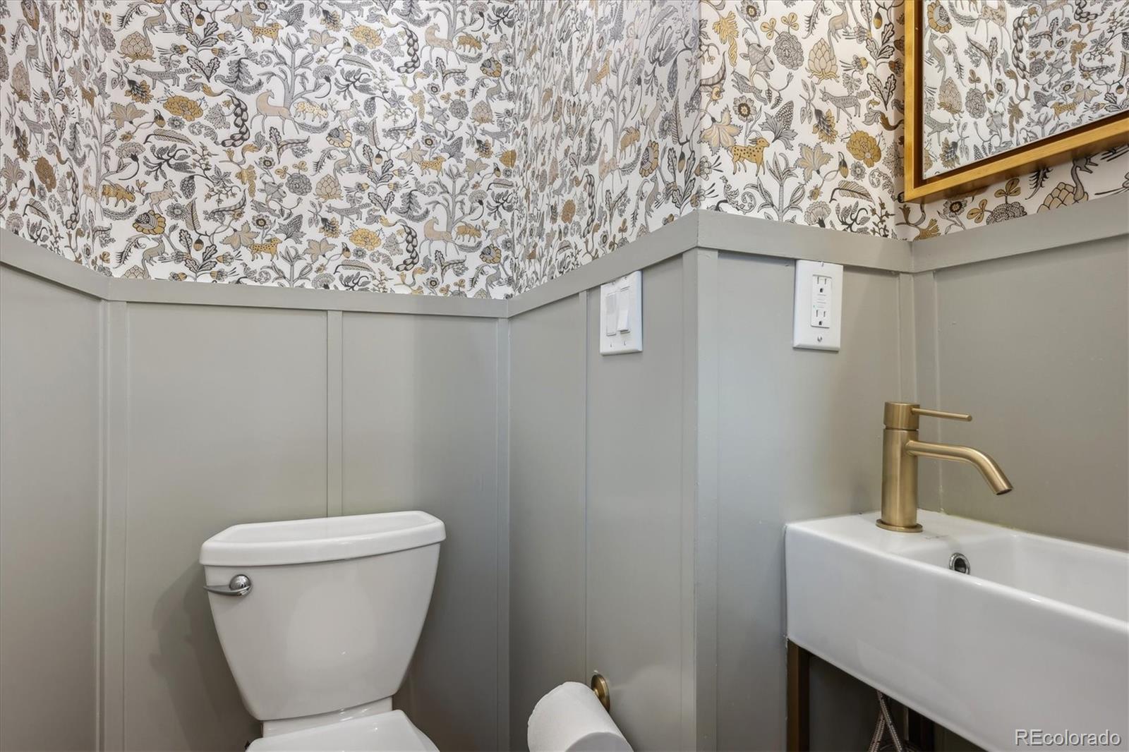 3200 Ames Street Wheat Ridge, CO 80212 - Photo 9 of 46 a bathroom with a toilet sink and mirror