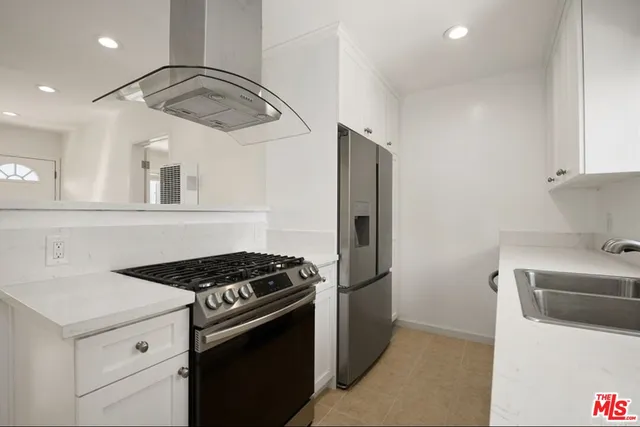 a kitchen with stainless steel appliances a refrigerator a sink and a stove