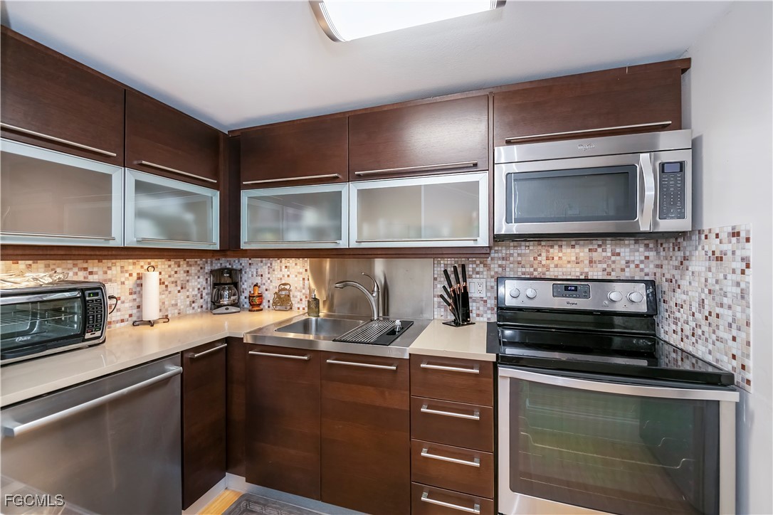 58 North Collier Boulevard, Unit 2010 Marco Island, FL 34145 - Photo 22 of 48 a kitchen with a sink and steel appliances