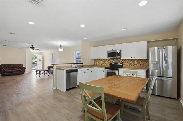 a kitchen with a refrigerator a stove top oven a sink and a island