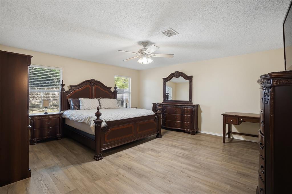 8704 Serenity Way Denton, TX 76210 - Photo 15 of 29 a bedroom with a bed and a chandelier