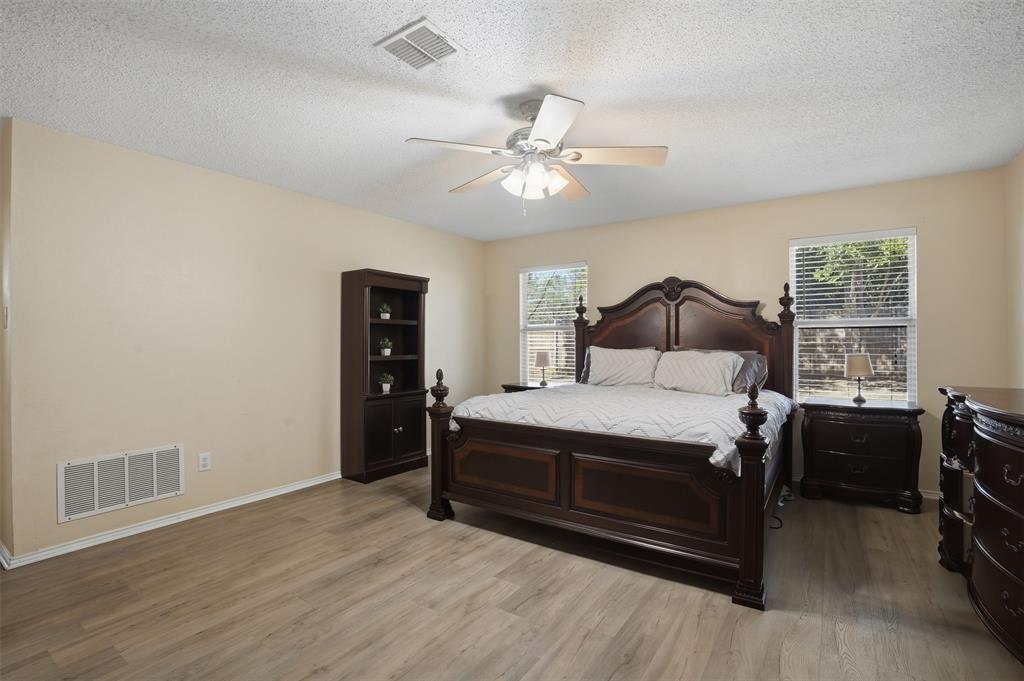 8704 Serenity Way Denton, TX 76210 - Photo 16 of 29 a bedroom with a bed and a chandelier