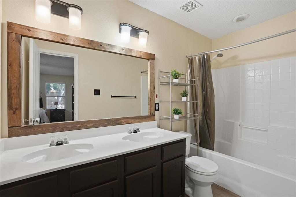 8704 Serenity Way Denton, TX 76210 - Photo 18 of 29 a bathroom with a double vanity sink toilet and shower