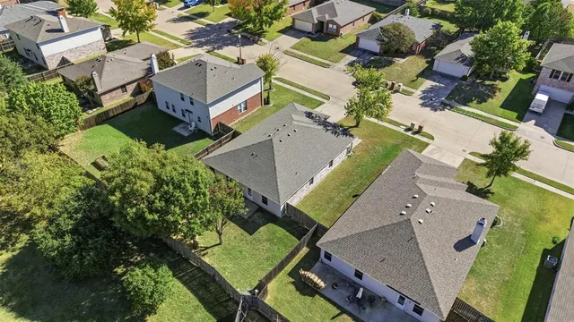 an aerial view of a house with a yard and pool