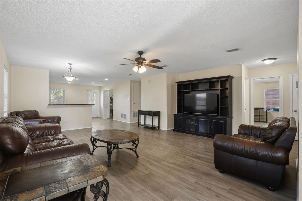 8704 Serenity Way Denton, TX 76210 - Photo 7 of 29 a living room with furniture and a flat screen tv