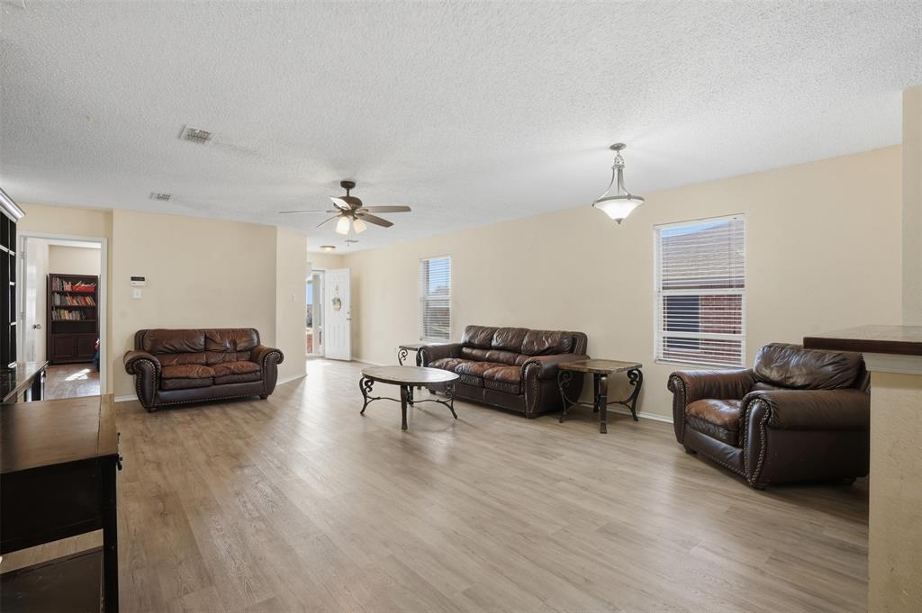8704 Serenity Way Denton, TX 76210 - Photo 9 of 29 a living room with furniture and a wooden floor