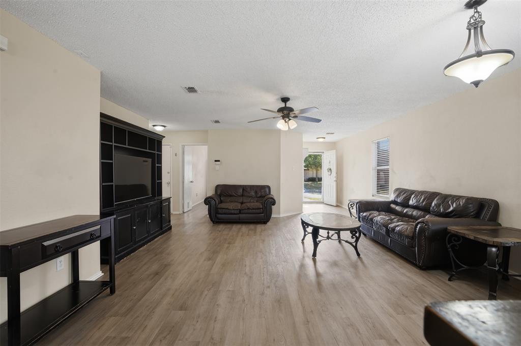 8704 Serenity Way Denton, TX 76210 - Photo 10 of 29 a living room with furniture and a flat screen tv