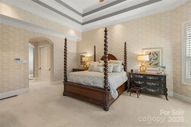 a bedroom with a large bed and a chandelier