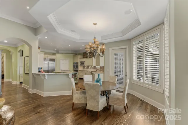 a dining room with furniture a chandelier and wooden floor