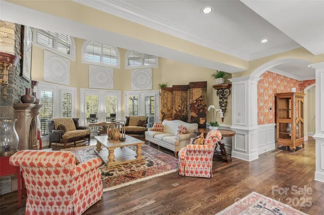 a living room with furniture wooden floor and a large window