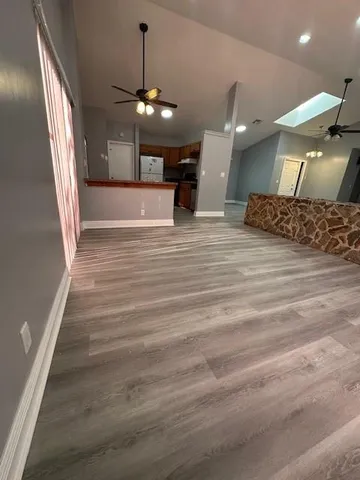 a view of a room with a chandelier and wooden floor